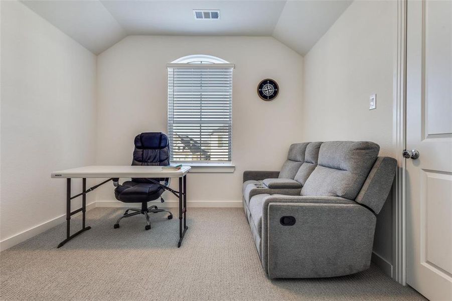 Office space featuring light carpet and vaulted ceiling Office space featuring light carpet and vaulted ceiling