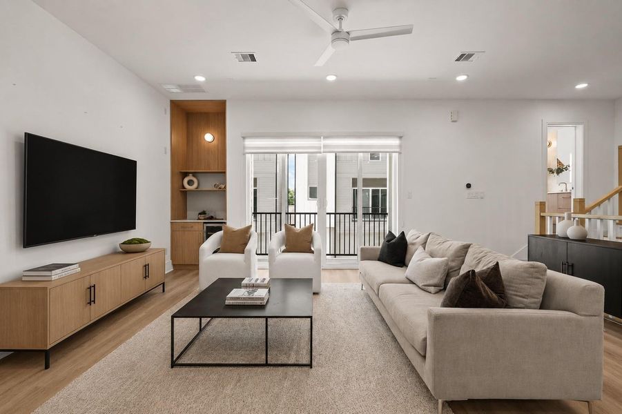 From its central position within the home, the kitchen frames a seamless progression of living spaces. Expansive balcony doors invite natural light into the interior and extend the living experience outward, reinforcing the home's emphasis on openness, connection, and everyday gathering.