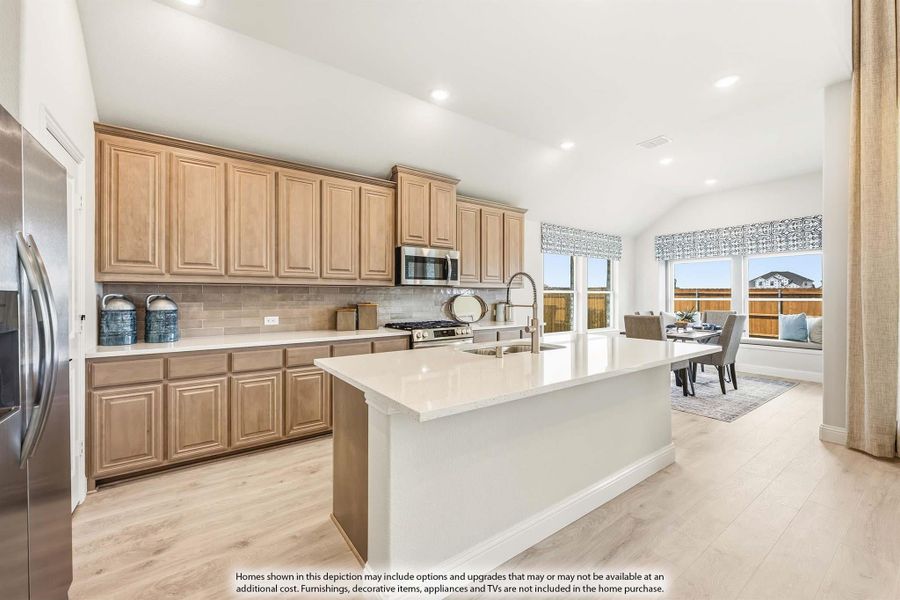 Kitchen with large center island, light wood cabinets, stainless appliances, and open view to dining area with windows