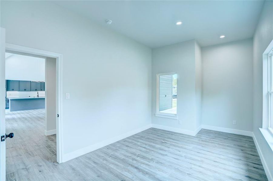 Light wood-finish flooring throughout, complemented by white baseboards and neutral wall tones