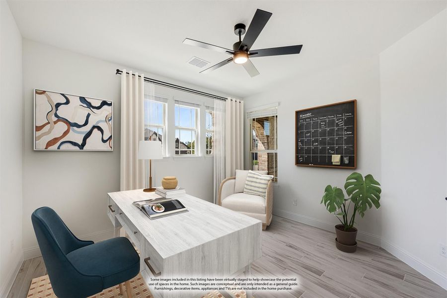 Home office with wood desk, ceiling fan, light wood floors, and two windows with sheer curtains Home office with wood desk, ceiling fan, light wood floors, and two windows with sheer curtains
