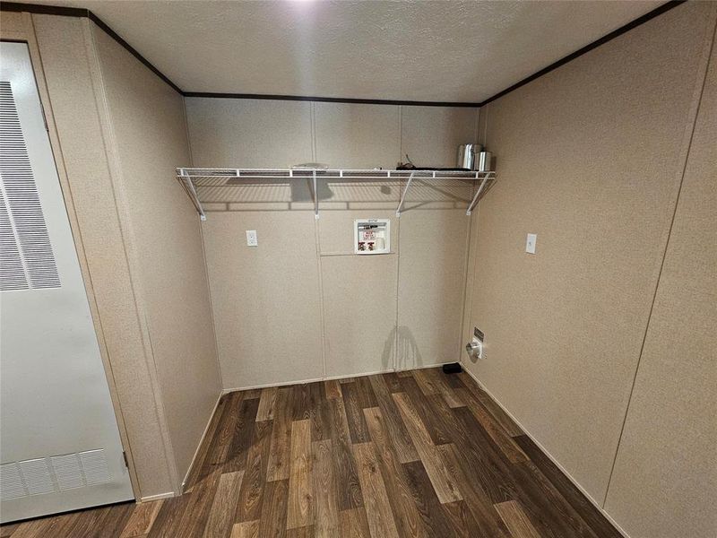 Laundry area with dark wood-style floors, a heating unit, a textured ceiling, and washer hookup Laundry area with dark wood-style floors, a heating unit, a textured ceiling, and washer hookup