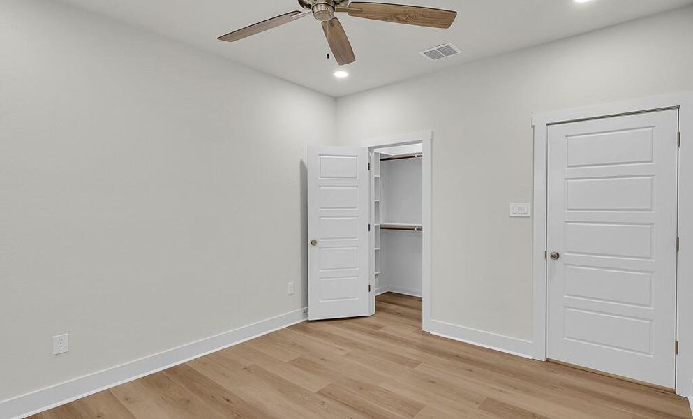 Unfurnished bedroom featuring light wood-style floors, a walk in closet, recessed lighting, and ceiling fan