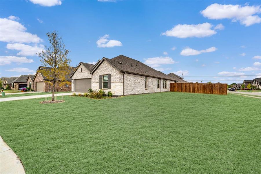 View of side of property with a yard and a garage