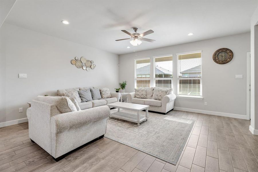 Living room featuring a ceiling fan, light wood-style floors, and recessed lighting