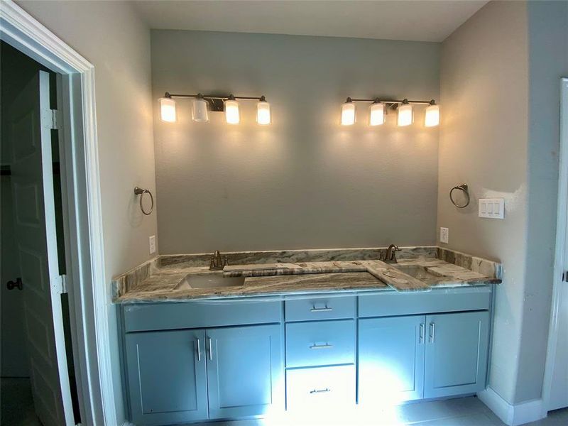 Master bath granite vanity with dual sinks, decorative lighting, and mirrors installed soon