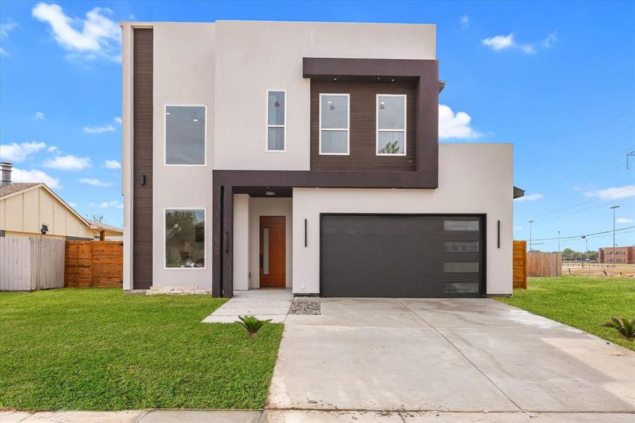 Contemporary house with stucco siding, driveway, and an attached garage Contemporary house with stucco siding, driveway, and an attached garage