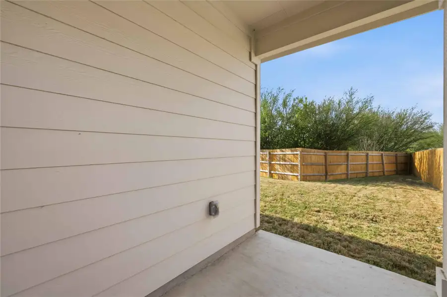 The covered patio overlooks the backyard and offers space for grilling out and seating in the shade. The covered patio overlooks the backyard and offers space for grilling out and seating in the shade.