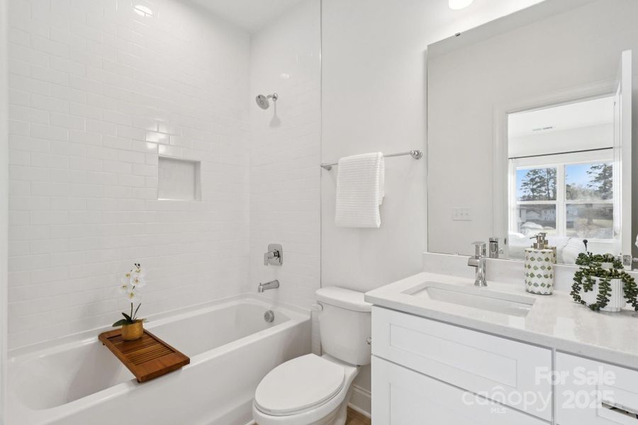 Large primary suite with massive walk-in closet and en suite bathroom with tiled shower wall