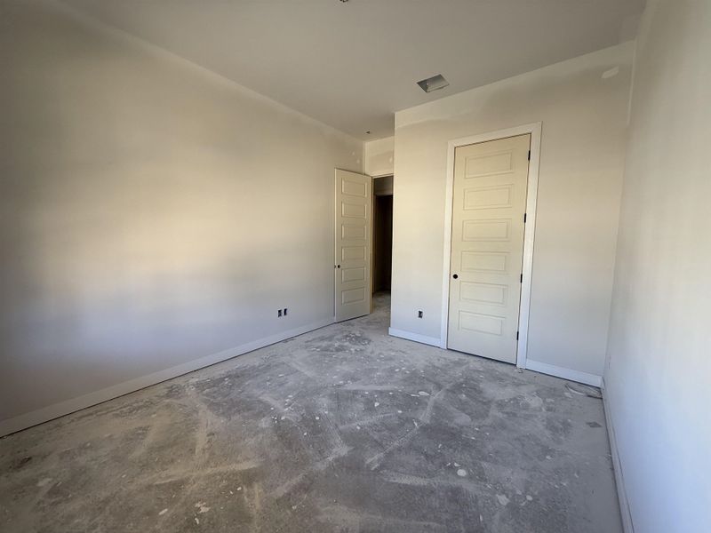 Unfurnished bedroom featuring concrete flooring and a closet