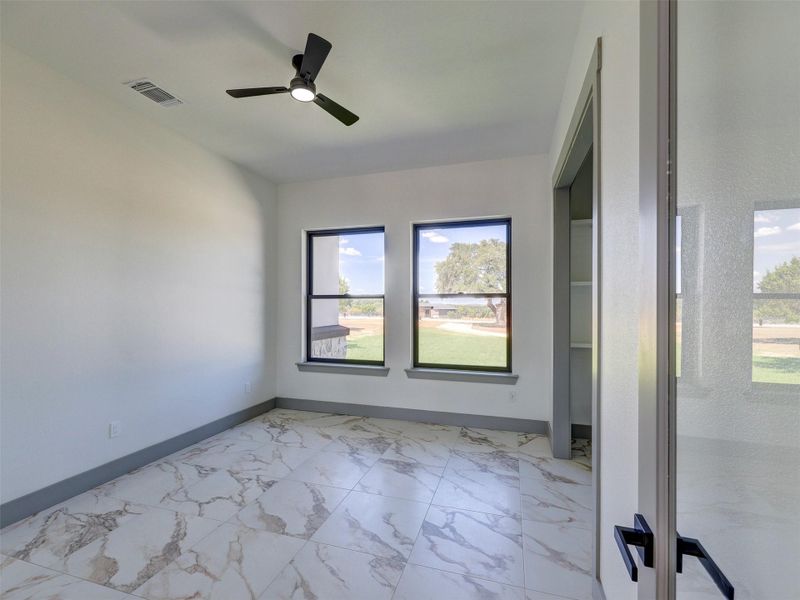 Polished tile flooring and double windows define this bright office space.