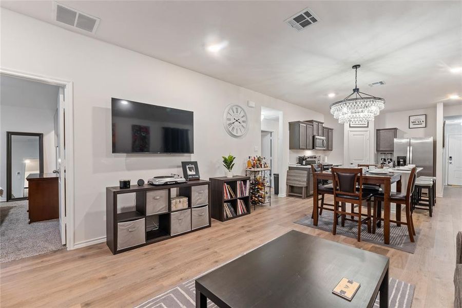 Living room featuring light wood-style floors and a chandelier