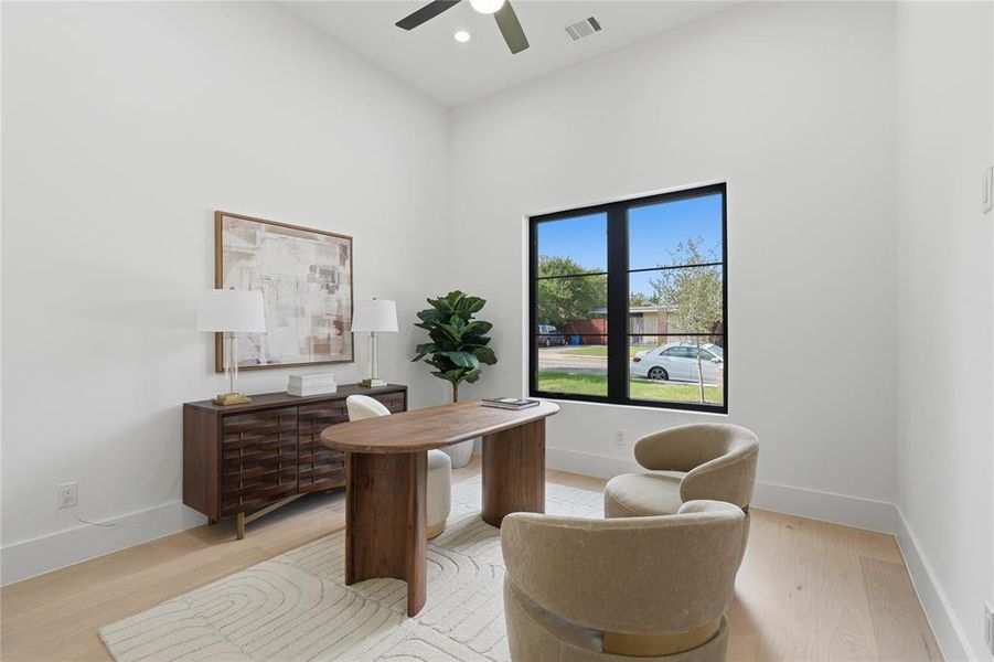 High ceilings with a ceiling fan, light wood-finish flooring, and a large black-framed window High ceilings with a ceiling fan, light wood-finish flooring, and a large black-framed window