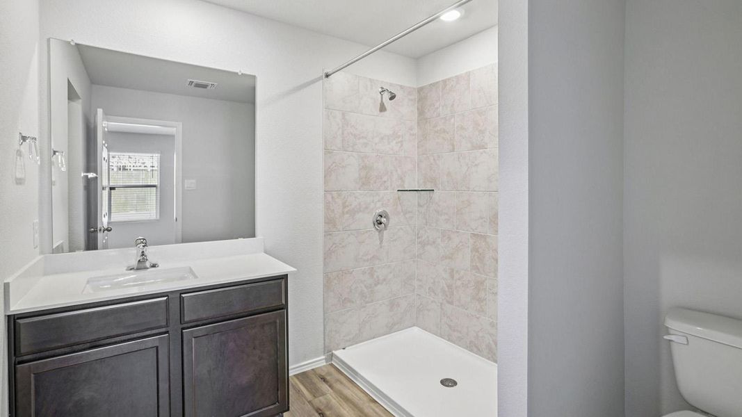Full bathroom with a stall shower, vanity, and light wood-type flooring