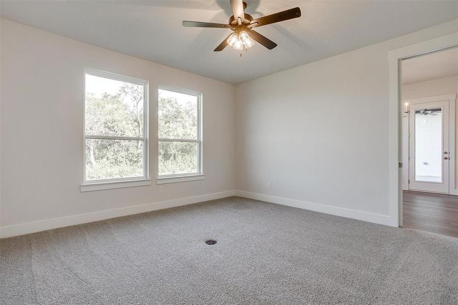 Carpeted spare room with ceiling fan