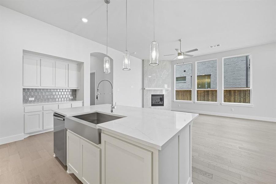 Kitchen featuring white cabinetry, light wood-style floors, light stone countertops, ceiling fan, and recessed lighting Kitchen featuring white cabinetry, light wood-style floors, light stone countertops, ceiling fan, and recessed lighting