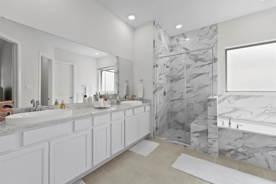 Luxurious ensuite with a soaking tub, separate glass shower, and dual vanities. Luxurious ensuite with a soaking tub, separate glass shower, and dual vanities.