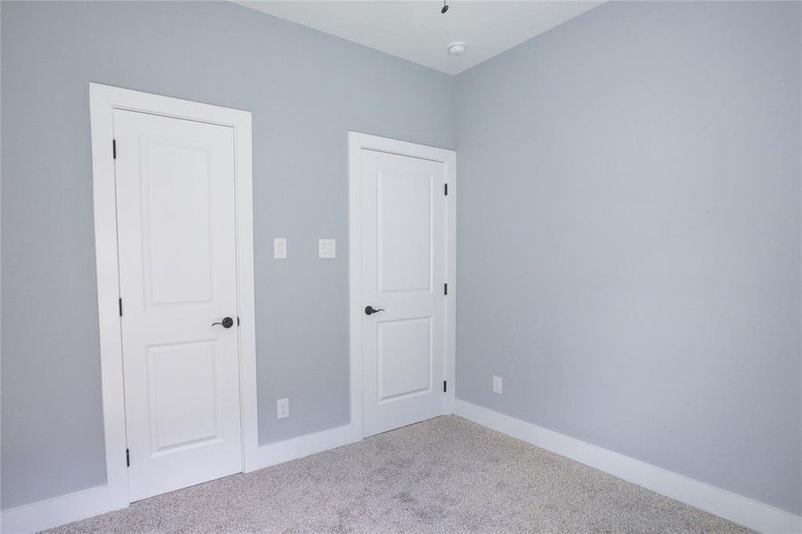 Unfurnished bedroom featuring carpet flooring and baseboards