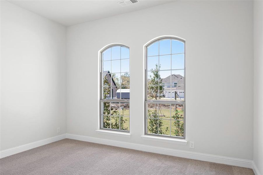 Spare room with light colored carpet and baseboards Spare room with light colored carpet and baseboards