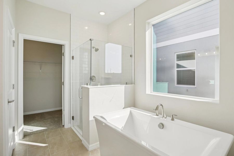 Primary bathroom with a free standing tub and a large frameless walk in shower