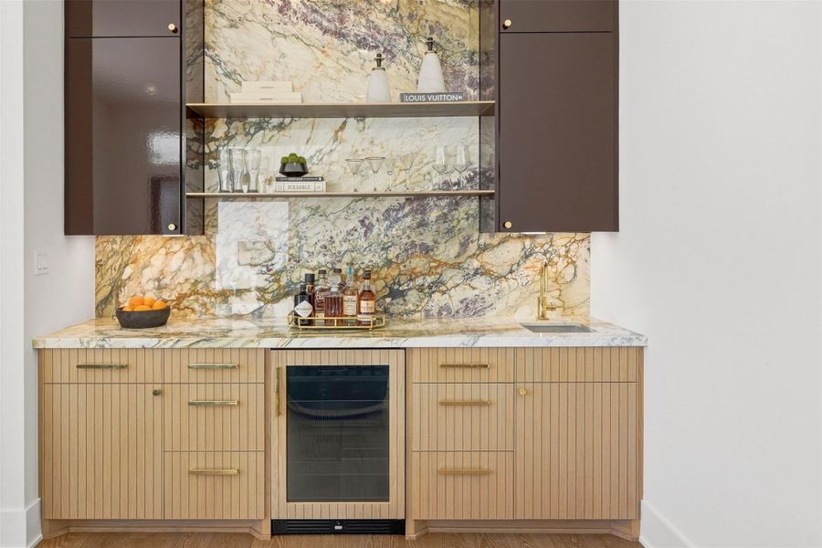 This exquisite bar captivates with its rare, Italian marble countertop and backsplash, complemented by custom cabinetry. Equipped with a thoughtfully-integrated sink, it offers a seamless balance of artistry and functionality, perfect for entertaining in unparalleled style. This exquisite bar captivates with its rare, Italian marble countertop and backsplash, complemented by custom cabinetry. Equipped with a thoughtfully-integrated sink, it offers a seamless balance of artistry and functionality, perfect for entertaining in unparalleled style.