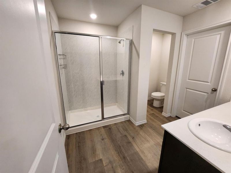 Full bath featuring vanity, a stall shower, and dark wood finished floors