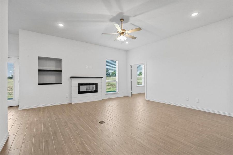 Unfurnished living room with light hardwood / wood-style floors and ceiling fan