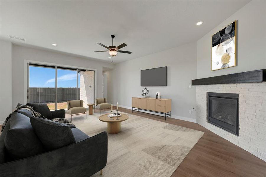 Living room featuring wood finished floors, a stone fireplace, recessed lighting, and ceiling fan