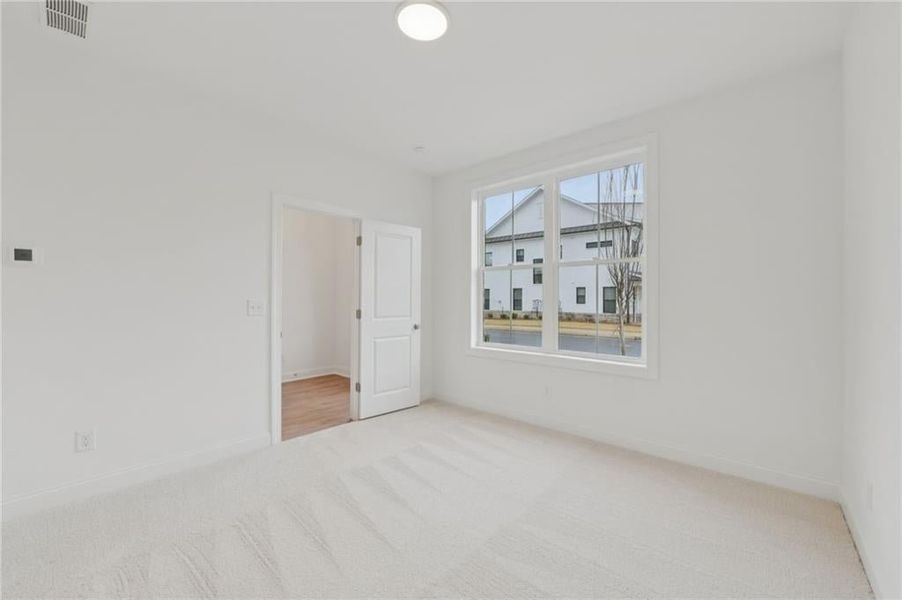 Bedroom on the main floor with its own bathroom - light colored carpet