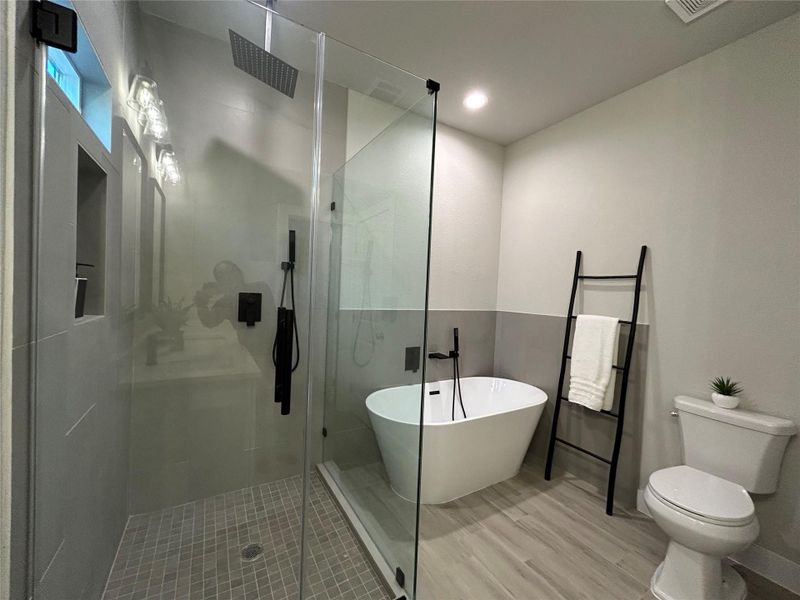 Primary bathroom with recessed lighting, soak in tub, and walk-in shower.