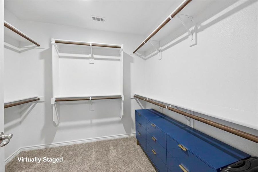 Walk in closet with light colored carpet