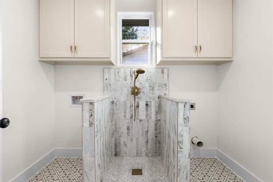 Laundry area with cabinets, hookup for a washing machine, and electric dryer hookup