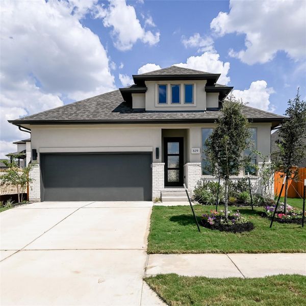 Prairie-style home featuring brick siding, stucco siding, concrete driveway, a shingled roof, and an attached garage Prairie-style home featuring brick siding, stucco siding, concrete driveway, a shingled roof, and an attached garage