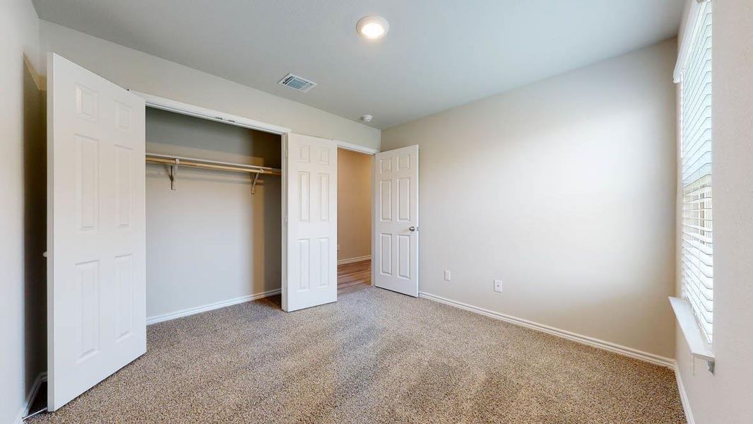 Neutral-toned room with plush carpet flooring