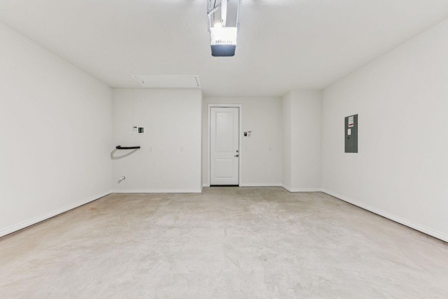 Garage featuring electric panel and a garage door opener Garage featuring electric panel and a garage door opener