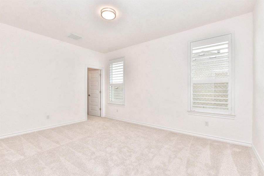 Unfurnished room featuring light carpet and baseboards
