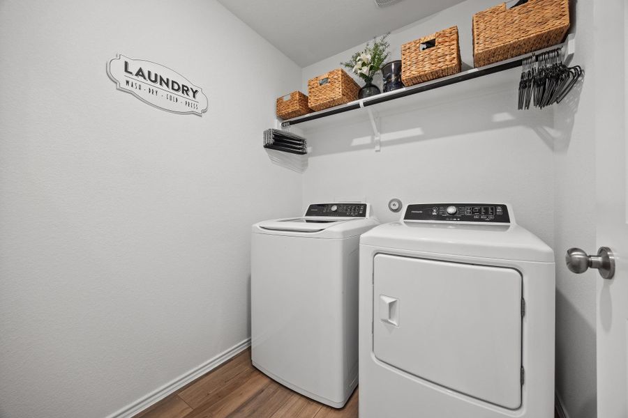 Spacious and clean laundry room equipped with shelf above for storage. Spacious and clean laundry room equipped with shelf above for storage.