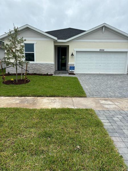 Front exterior of a new home in Azalea, Port St. Lucie, FL, highlighting curb appeal (Image 1).