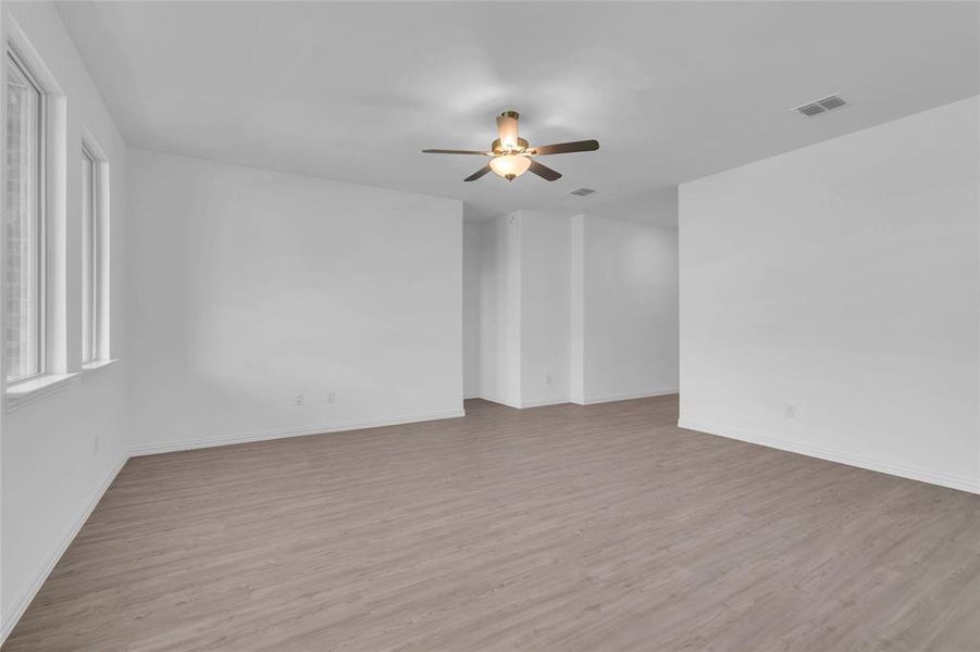 Empty room with ceiling fan and light hardwood / wood-style flooring