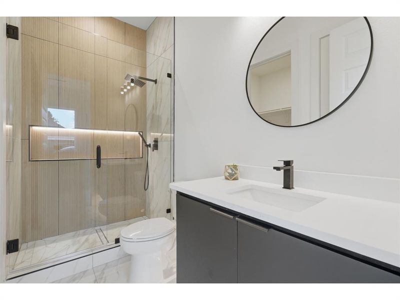 White vanity with an integrated sink and matte black faucet, paired with a circular mirror