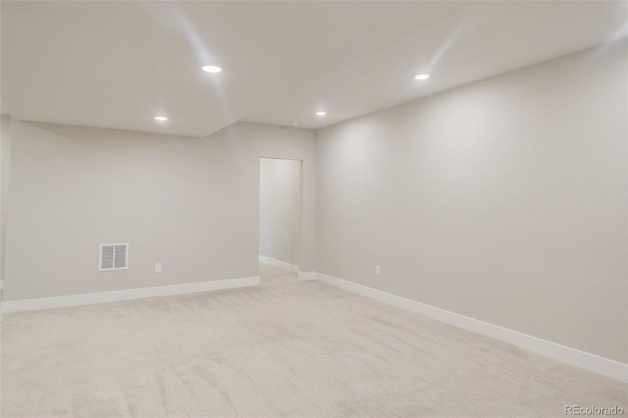 View of the family room from the stairs, toward the back hallway leading to the bedrooms and third bath. View of the family room from the stairs, toward the back hallway leading to the bedrooms and third bath.