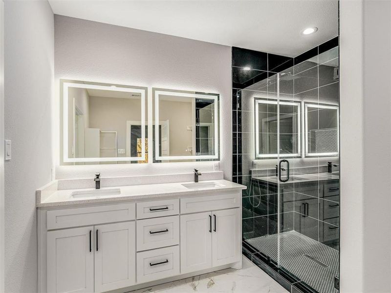 Bathroom with double vanity, light marble finish floors, a stall shower, and recessed lighting Bathroom with double vanity, light marble finish floors, a stall shower, and recessed lighting