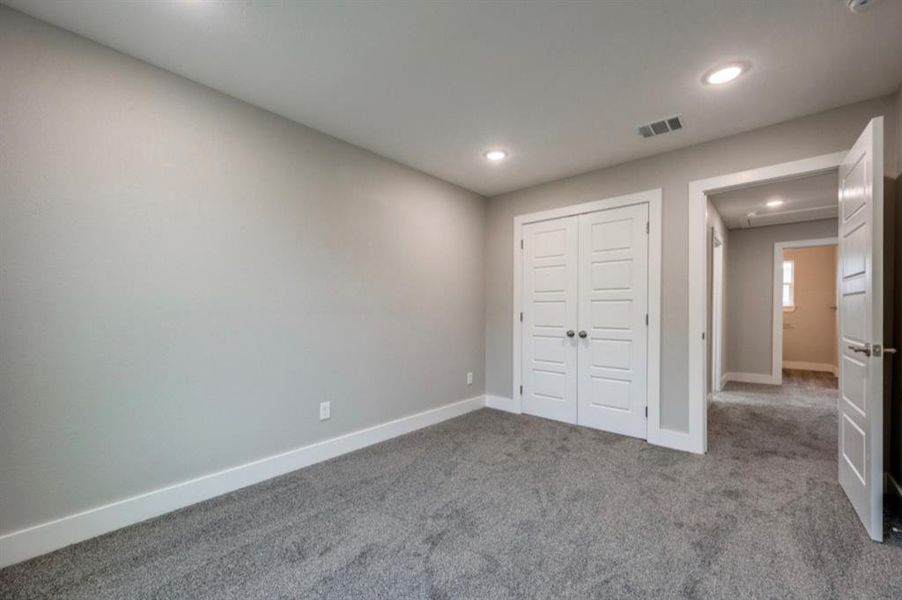 Unfurnished bedroom with carpet floors, a closet, and recessed lighting