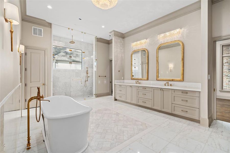 The en suite owner's bathroom is a spa-like sanctuary where white marble surrounds a freestanding soaking tub, windowed rain shower and wide double vanity.