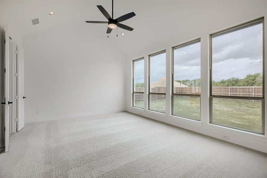 Empty room featuring light colored carpet, ceiling fan, recessed lighting, and lofted ceiling