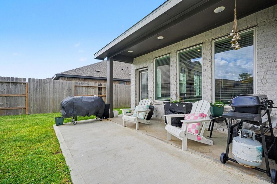 Covered patio with space for outdoor seating and grilling, creating a comfortable spot to enjoy the backyard. Covered patio with space for outdoor seating and grilling, creating a comfortable spot to enjoy the backyard.