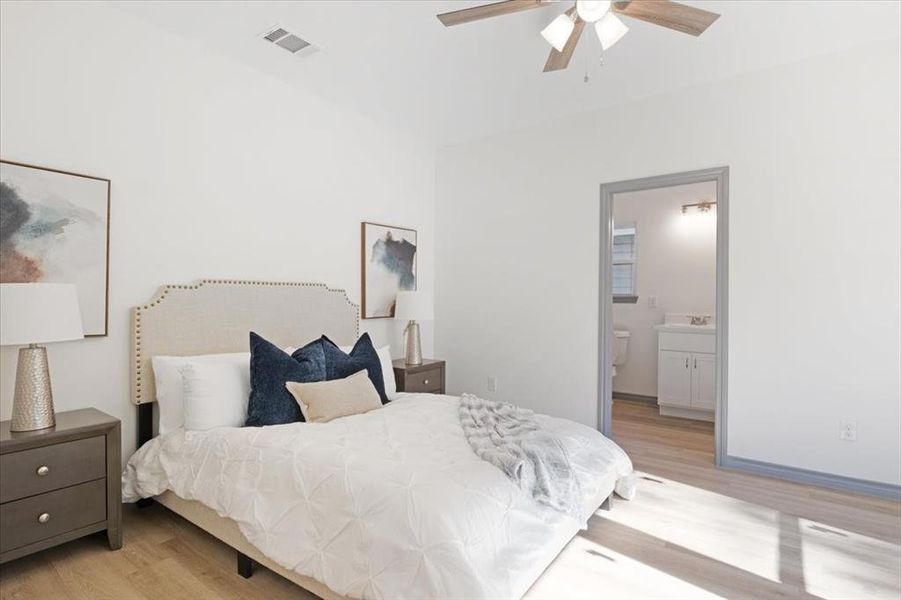 Bedroom with connected bathroom, ceiling fan, and light hardwood / wood-style floors