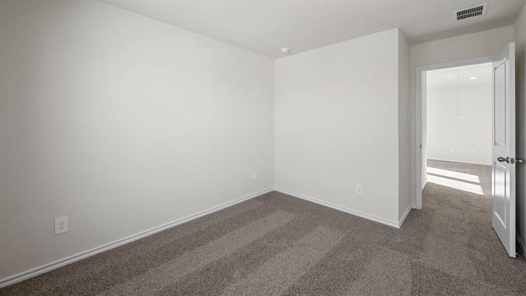 Spare room with dark colored carpet and baseboards