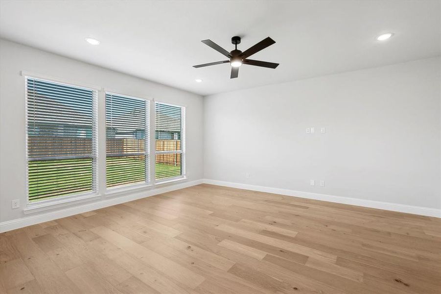 Empty room with a ceiling fan, baseboards, light wood finished floors, and recessed lighting