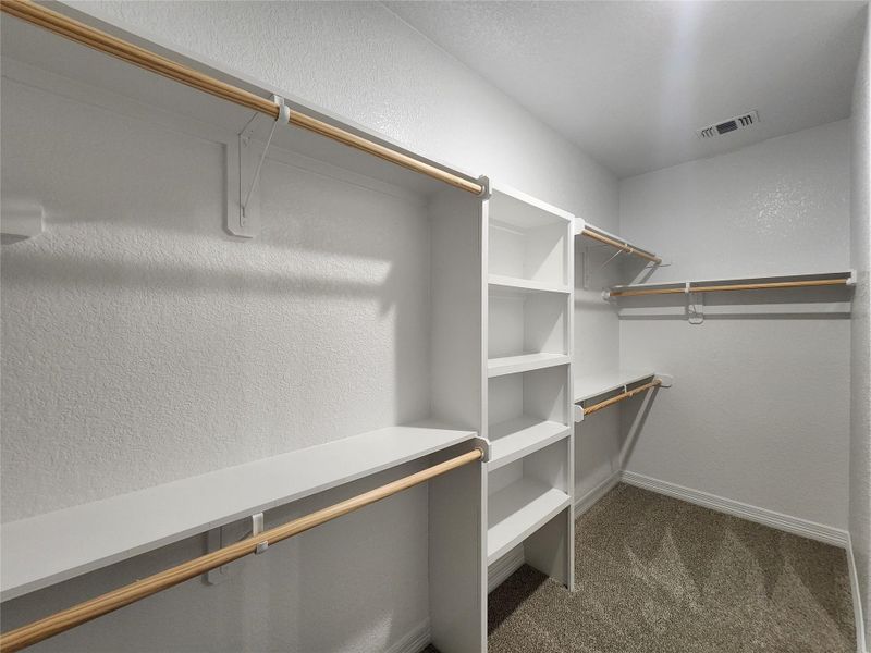 Ample shelving and hanging space in this well-organized walk-in closet. Ample shelving and hanging space in this well-organized walk-in closet.